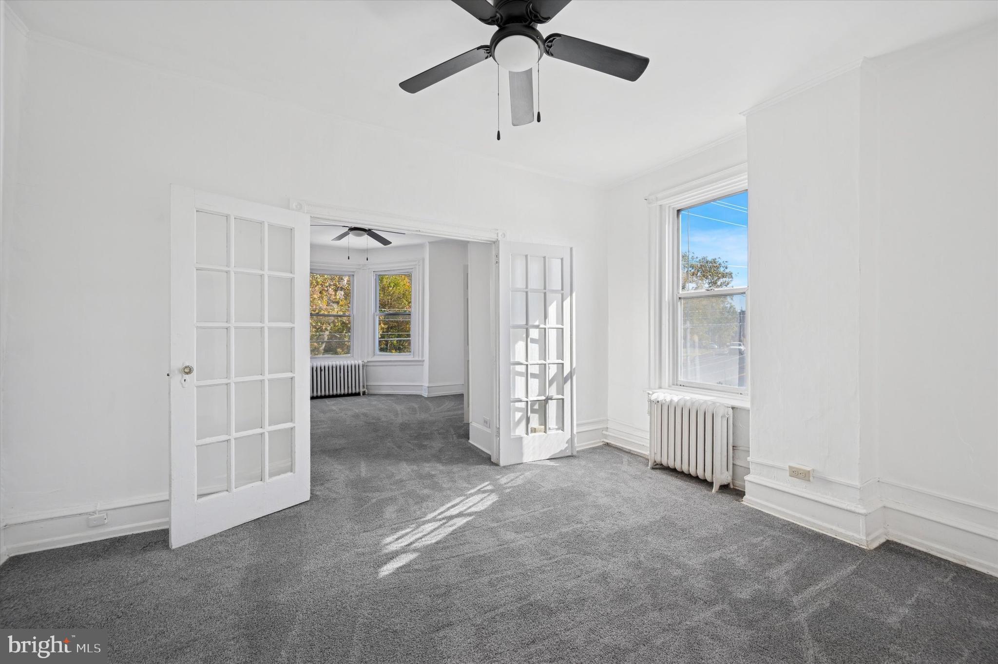 5262 Parkside Avenue Philadelphia, PA 19131 - Photo 12 of 14 an empty room with windows and ceiling fan