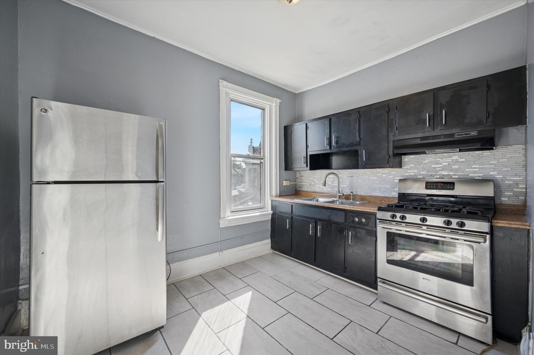 5262 Parkside Avenue Philadelphia, PA 19131 - Photo 9 of 14 a kitchen with stainless steel appliances granite countertop a refrigerator stove a sink and a microwave