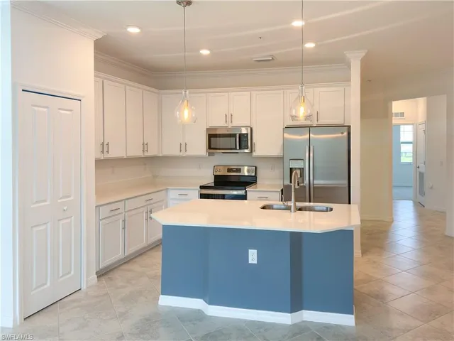a kitchen with kitchen island a sink stainless steel appliances and counter space