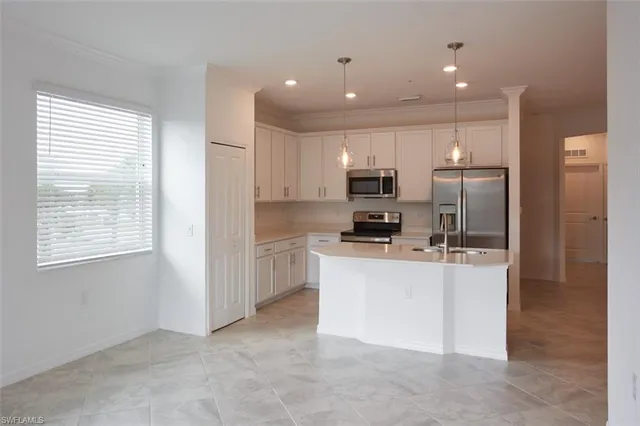 a kitchen with kitchen island white cabinets and refrigerator