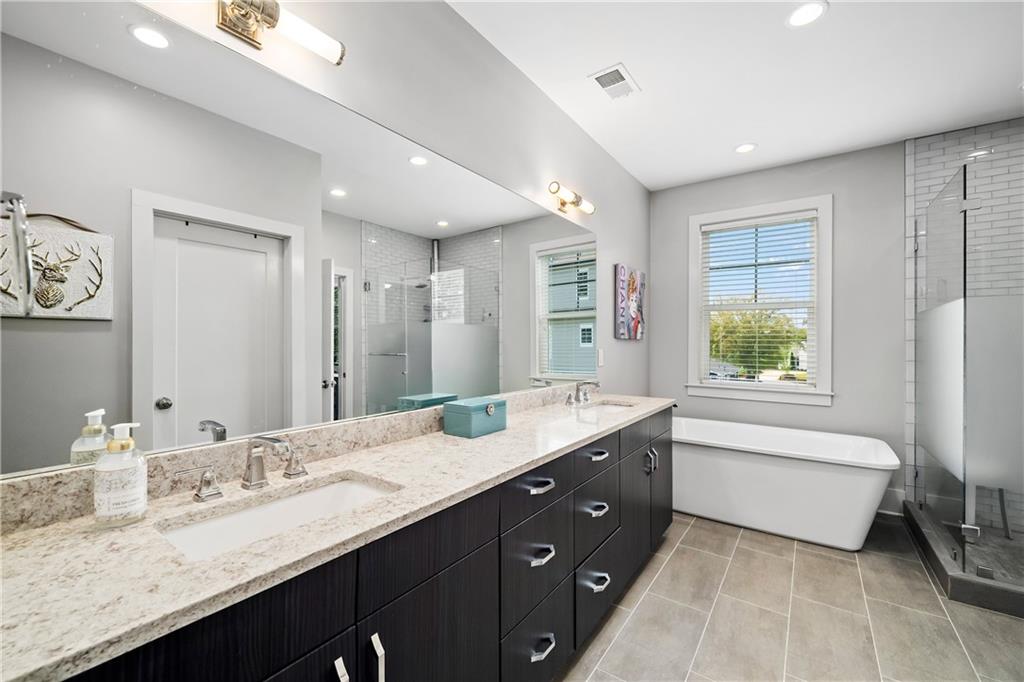 108 Canton Way Roswell, GA 30075 - Photo 20 of 46 a bathroom with a granite countertop double vanity sink a large mirror a bathtub and window