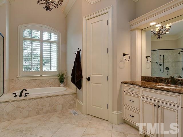 2921 Cone Manor Lane Raleigh, NC 27613 - Photo 14 of 25 a spacious bathroom with a granite countertop sink a mirror and a bathtub