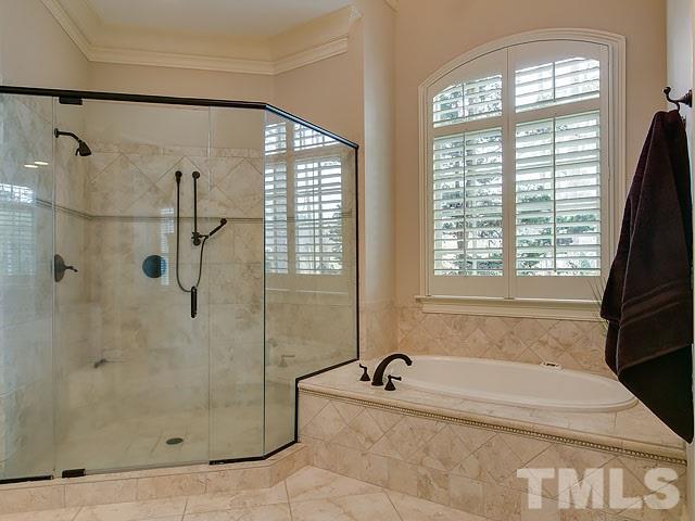 2921 Cone Manor Lane Raleigh, NC 27613 - Photo 15 of 25 a bathroom with a granite countertop bathtub shower and window