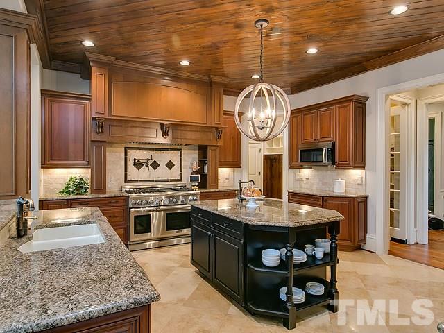 2921 Cone Manor Lane Raleigh, NC 27613 - Photo 4 of 25 a kitchen with stainless steel appliances granite countertop a stove and cabinets