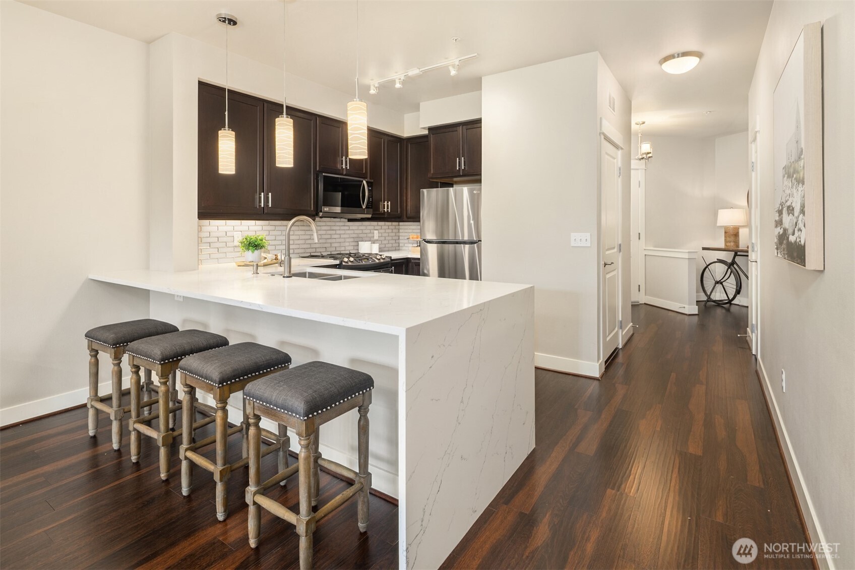 15700 116th Avenue Northeast, Unit 404 Bothell, WA 98011 - Photo 7 of 31 a kitchen with stainless steel appliances kitchen island granite countertop a table chairs sink and cabinets