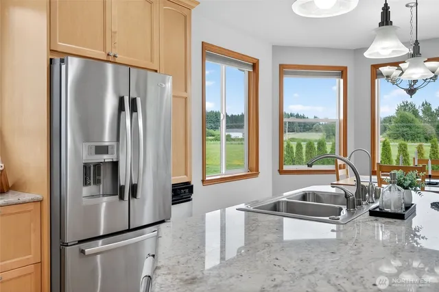 a kitchen with stainless steel appliances granite countertop a stove a sink and a wooden floors