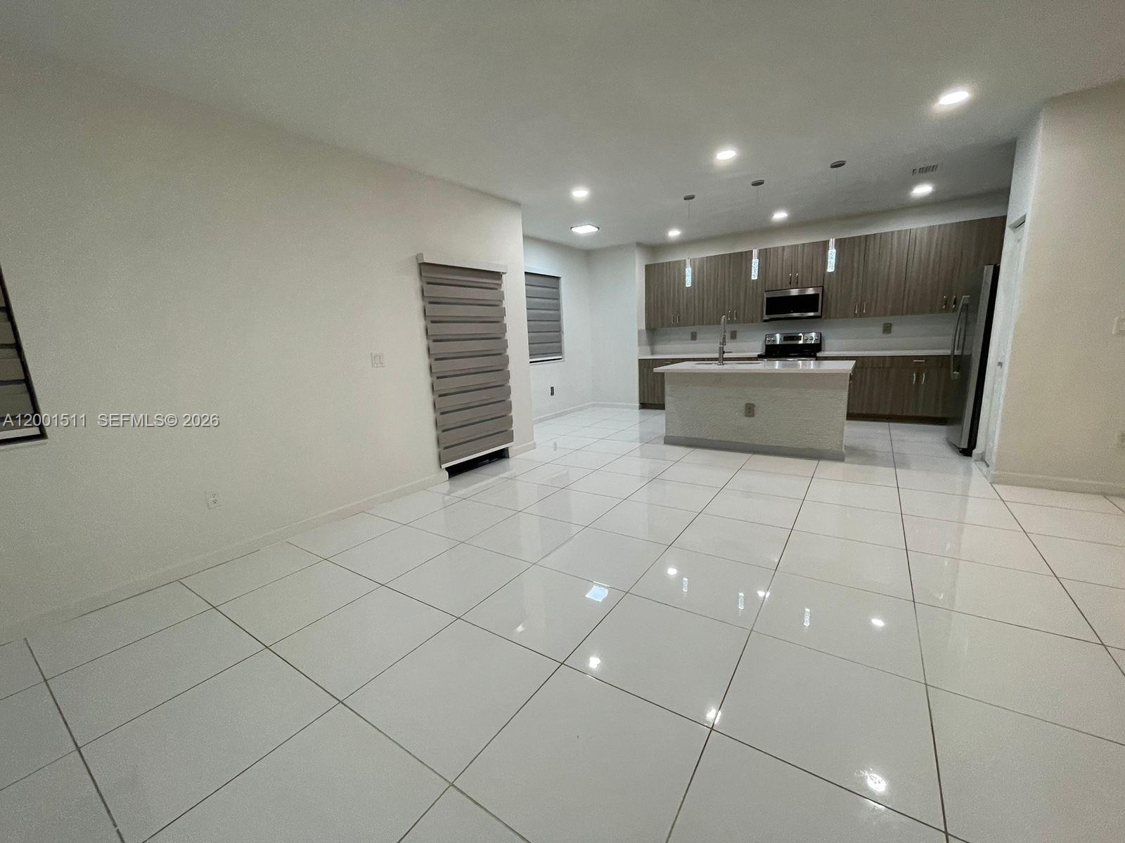 4451 Southwest 159th Path Miami, FL 33185 - Photo 6 of 24 a large white kitchen with a sink and cabinets