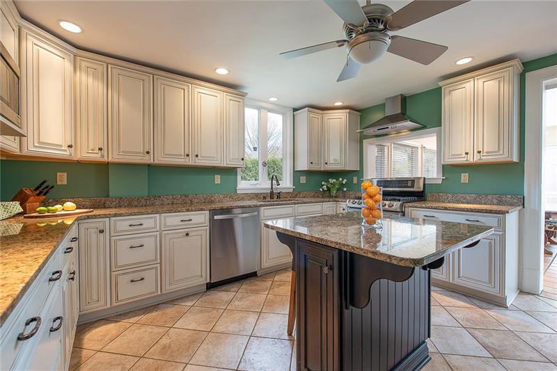 304 Quaker Road Sewickley, PA 15143 - Photo 8 of 25 A center island, granite counters, and stainless appliances are features in the updated kitchen.