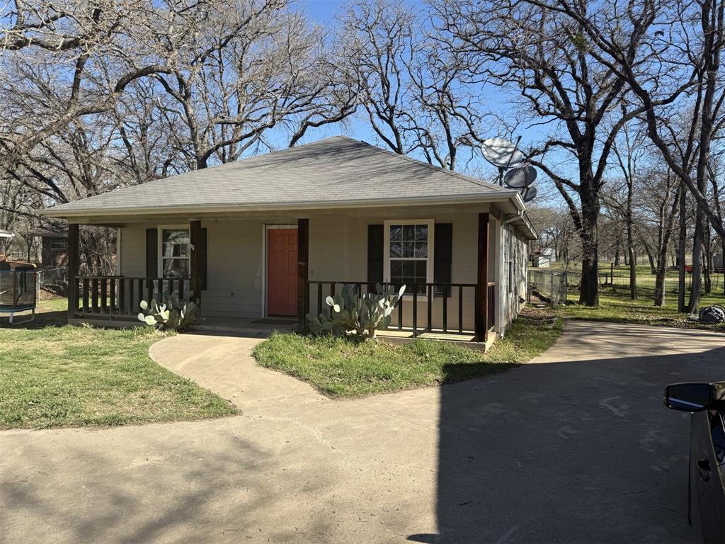 900 Reese Lane Azle, TX 76020 - Photo 2 of 15 a front view of a house with garden and trees