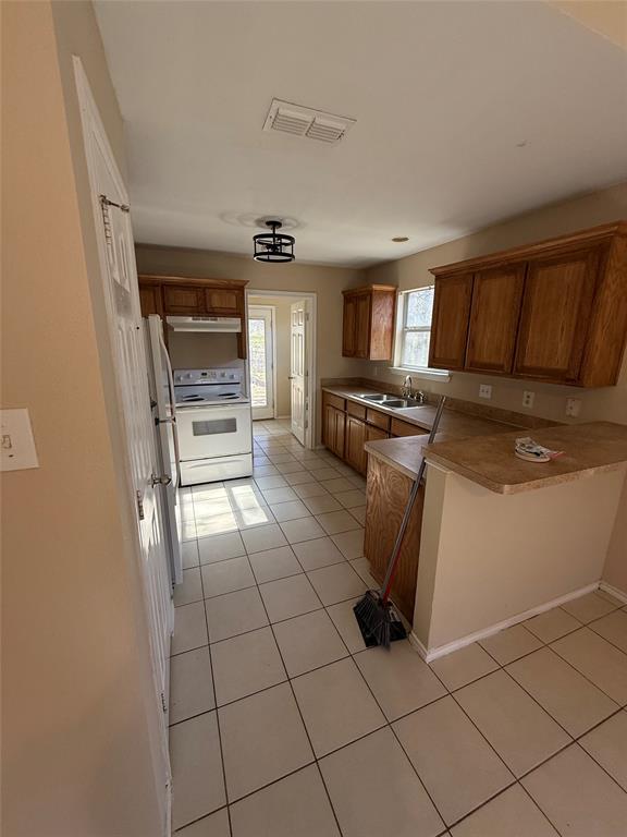 900 Reese Lane Azle, TX 76020 - Photo 8 of 15 a kitchen with granite countertop a stove a sink and a refrigerator