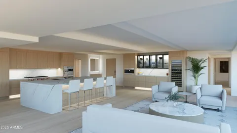 a living room with granite countertop couches a coffee table and kitchen view with wooden floor