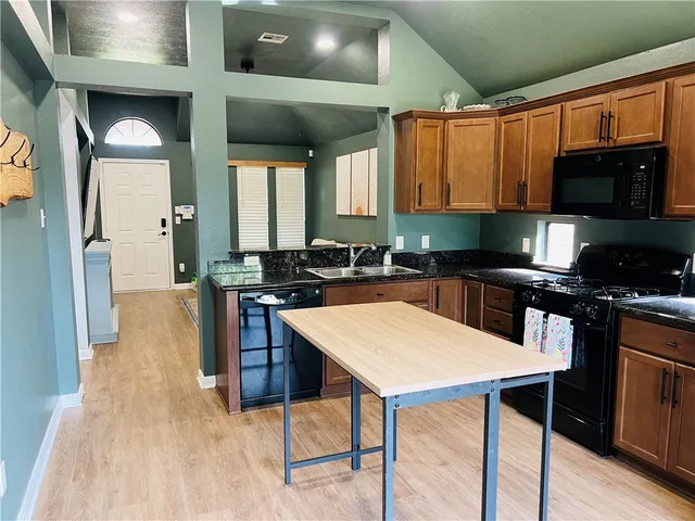 a kitchen with stainless steel appliances granite countertop a stove refrigerator and microwave