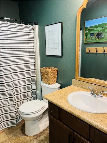 a bedroom with a bed and painting on the wall