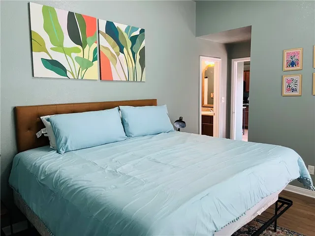 a large white bed in a bedroom next to a window