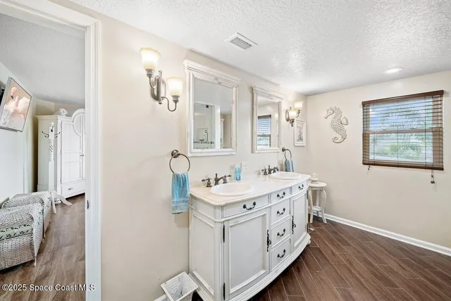 a kitchen with a stove a refrigerator a sink and dining table with wooden floor