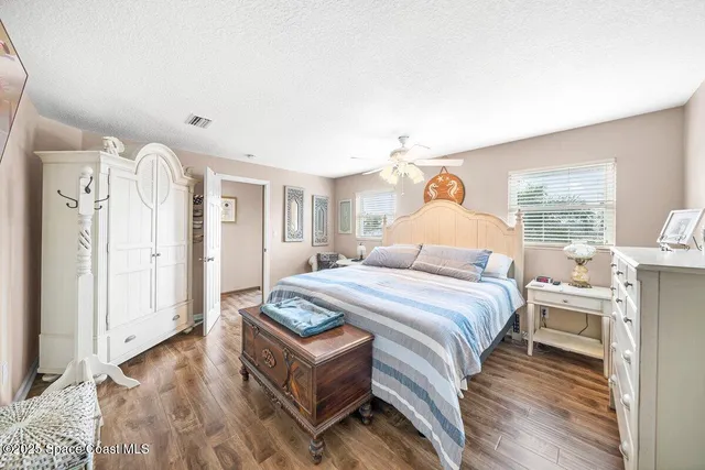 a dining hall with stainless steel appliances kitchen island granite countertop a table and chairs with wooden floor