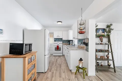 a kitchen with stainless steel appliances kitchen island granite countertop a refrigerator a stove top oven a sink and dishwasher