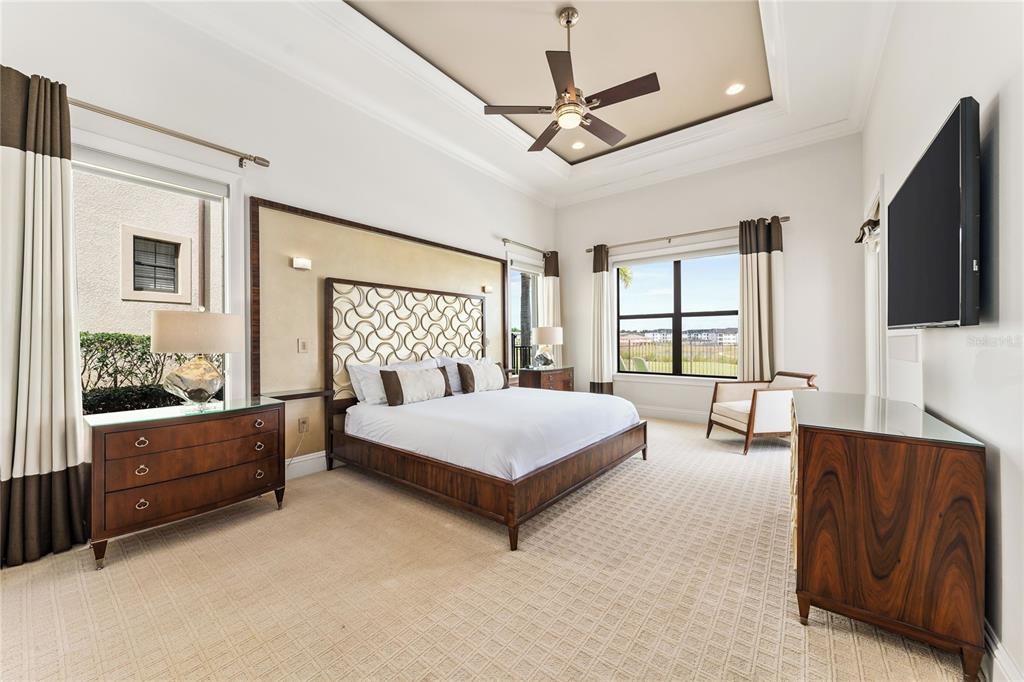 460 Muirfield Loop Reunion, FL 34747 - Photo 30 of 60 a spacious bedroom with a large bed and a flat screen television