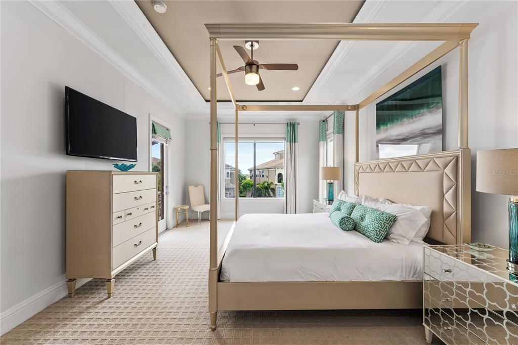 460 Muirfield Loop Reunion, FL 34747 - Photo 33 of 60 a bedroom with a large bed and a flat tv screen on dresser