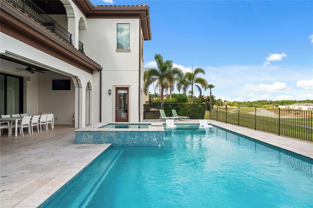 460 Muirfield Loop Reunion, FL 34747 - Photo 55 of 60 a view of a swimming pool with a lawn chairs and floor to ceiling window