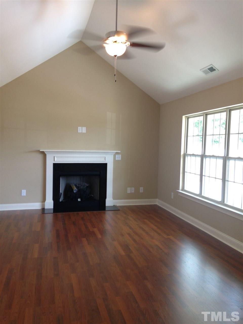 106 Orkney Road Stem, NC 27581 - Photo 3 of 21 an empty room with wooden floor fireplace and window