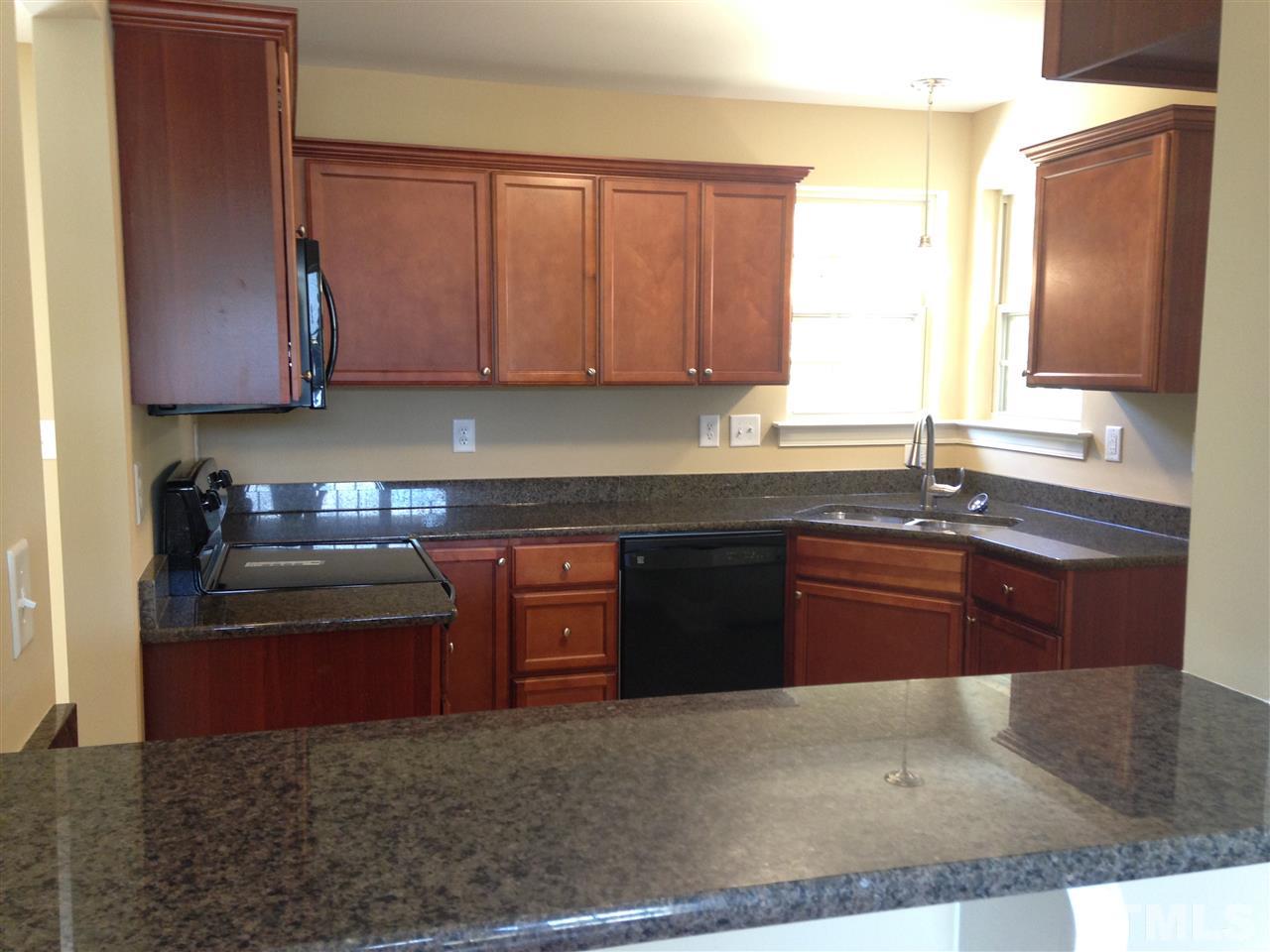 106 Orkney Road Stem, NC 27581 - Photo 4 of 21 a kitchen with granite countertop a sink and a stove top oven