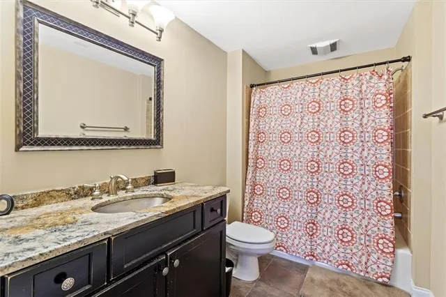 a bathroom with a granite countertop sink mirror and toilet