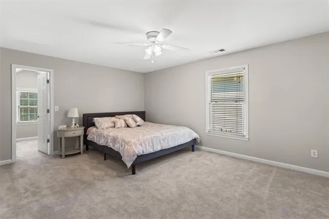 a spacious bedroom with a bed and a chandelier