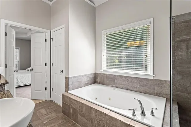 a bathroom with a tub a sink and a window