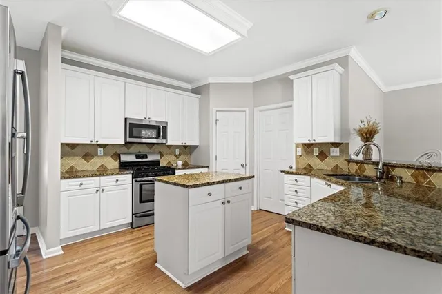 a kitchen with stainless steel appliances granite countertop a stove a sink dishwasher and a refrigerator