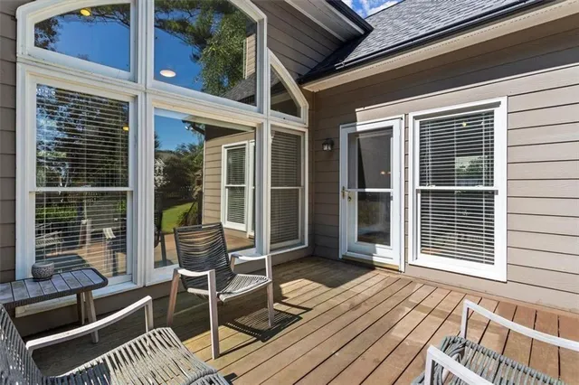 a view of a balcony with two chairs and wooden floor