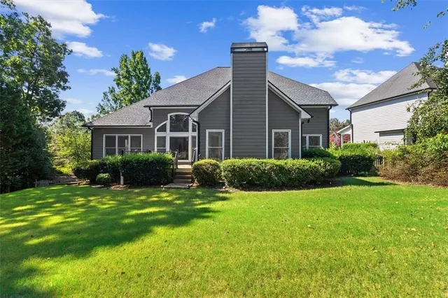 a view of a house with a yard potted plants and large tree