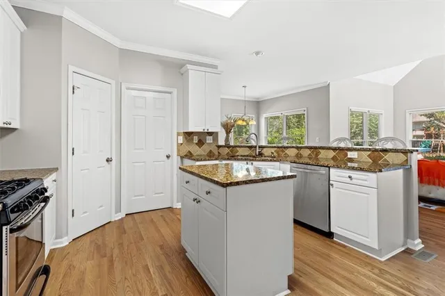 a kitchen with granite countertop a sink cabinets and wooden floor