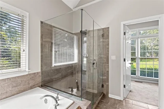 a bathroom with a tub a sink and a window