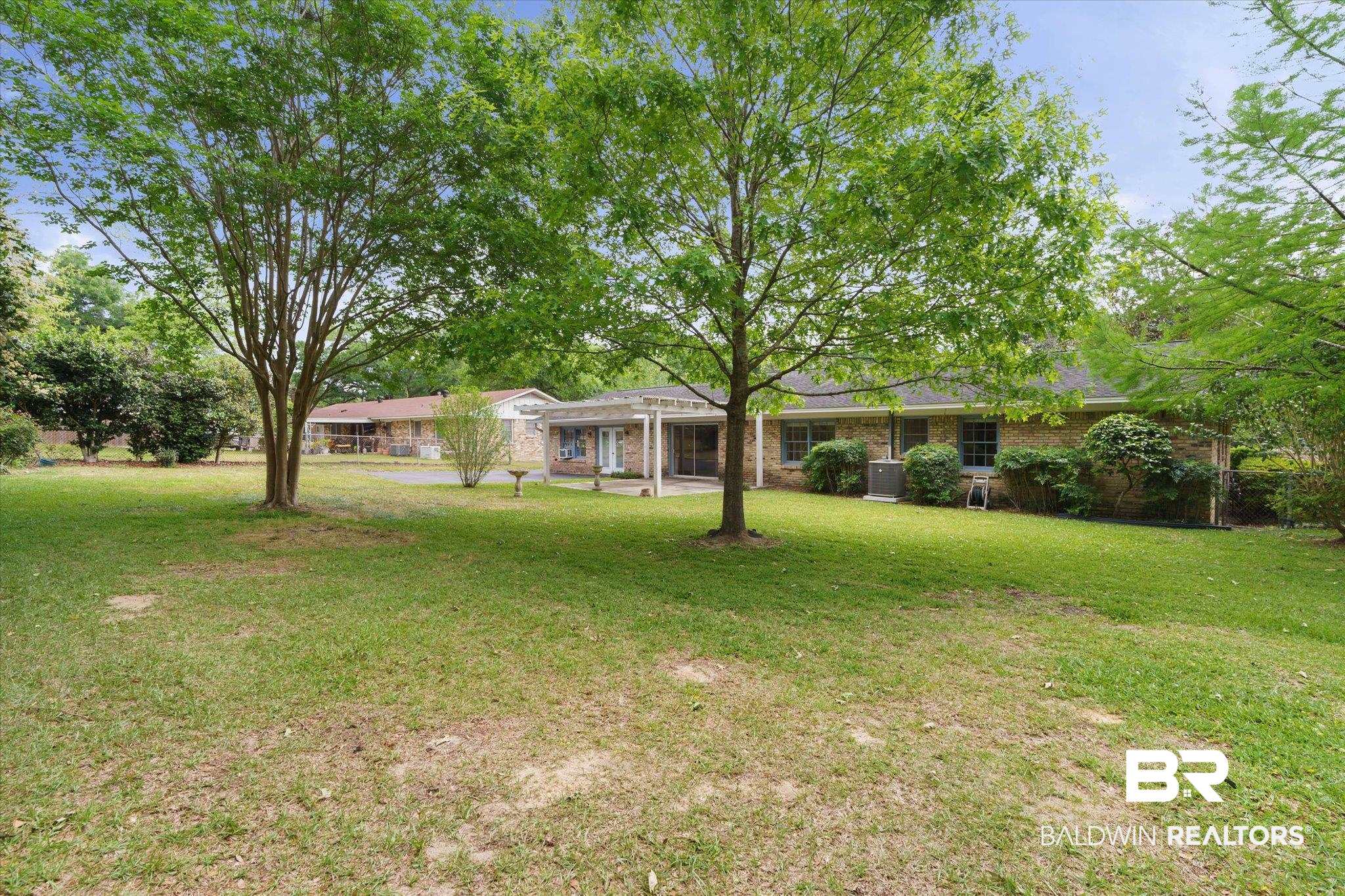 1182 Ginger Drive Mobile, AL 36693 - Photo 31 of 37 Expansive lawn area featuring mature trees and a brick-sided residence with multiple windows