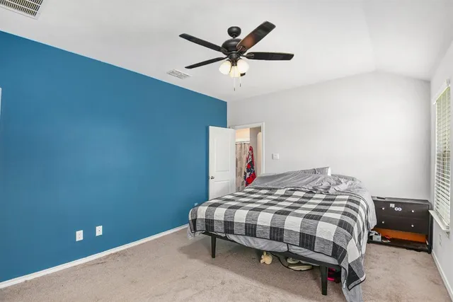 a bedroom with a bed and a ceiling fan