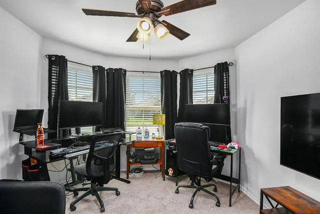 a view of a workspace with furniture and a window