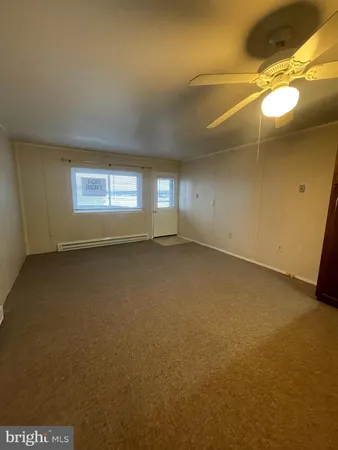 en empty room with windows and fan