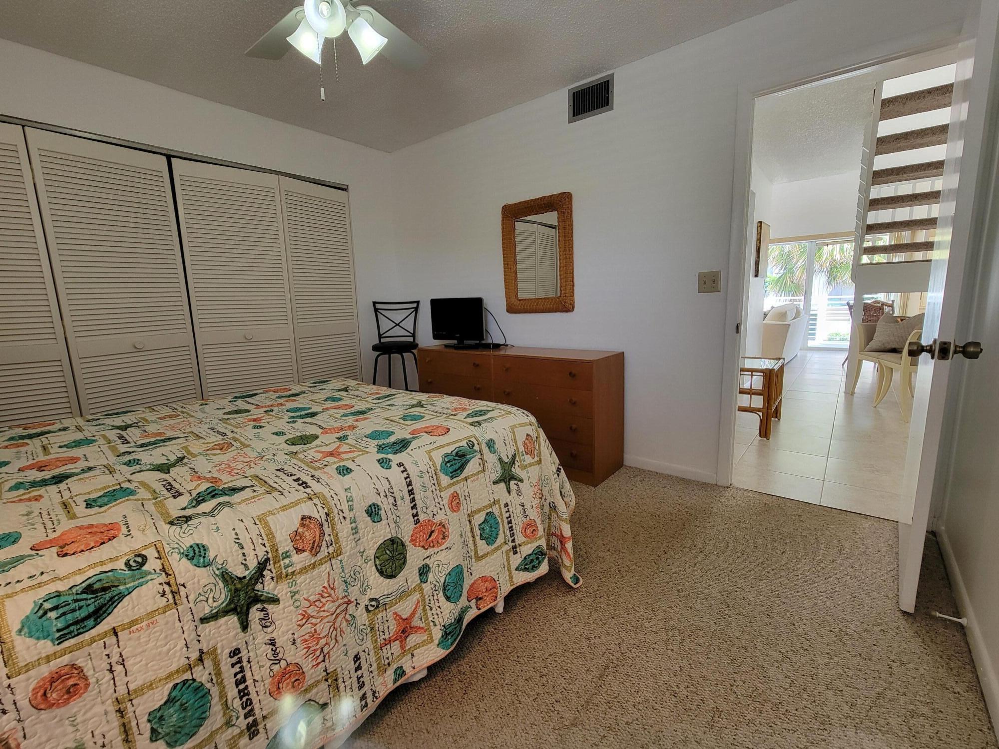 1605 Highway 1, Unit M2210 Jupiter, FL 33477 - Photo 7 of 28 a bedroom with a bed and a chandelier