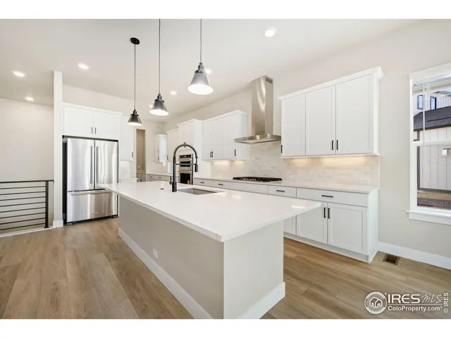 a kitchen with kitchen island a sink stainless steel appliances and cabinets