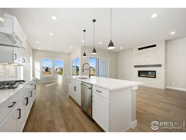 a kitchen with stainless steel appliances kitchen island a stove a sink a refrigerator and a view of living room