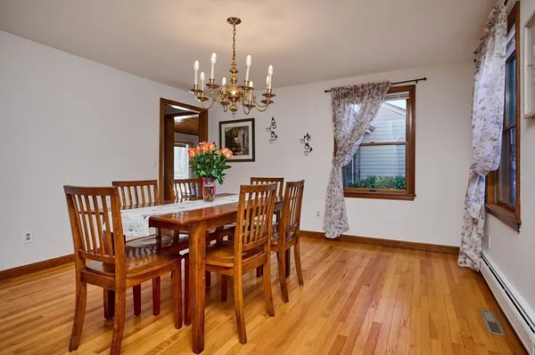 a view of a dining room with furniture wooden floor and chandelier