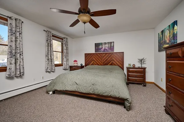 a spacious bedroom with a bed and a ceiling fan