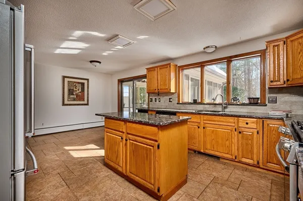 a kitchen with stainless steel appliances granite countertop a stove a sink and a refrigerator