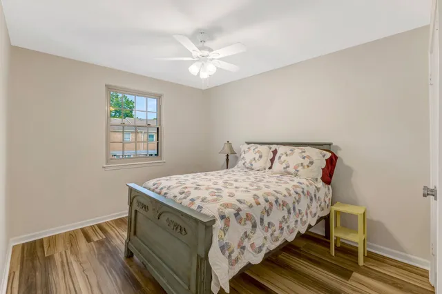 a view of a room with wooden floor and a chandelier fan