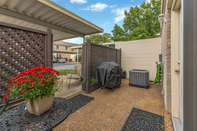 a view of a porch with a table and chair and potted plants