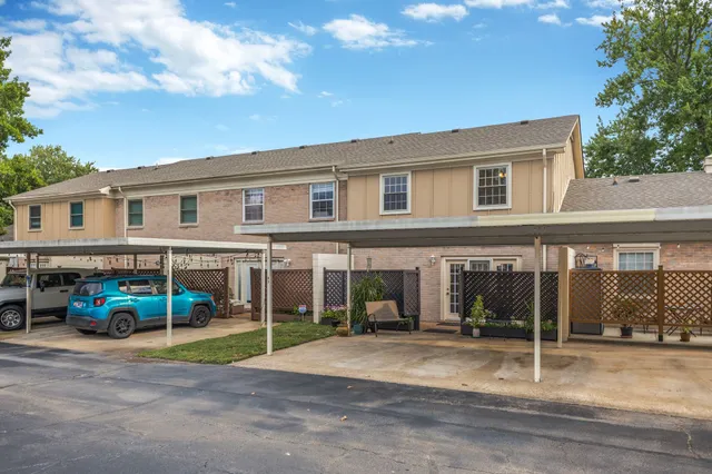 a view of a white house with a big yard and large trees