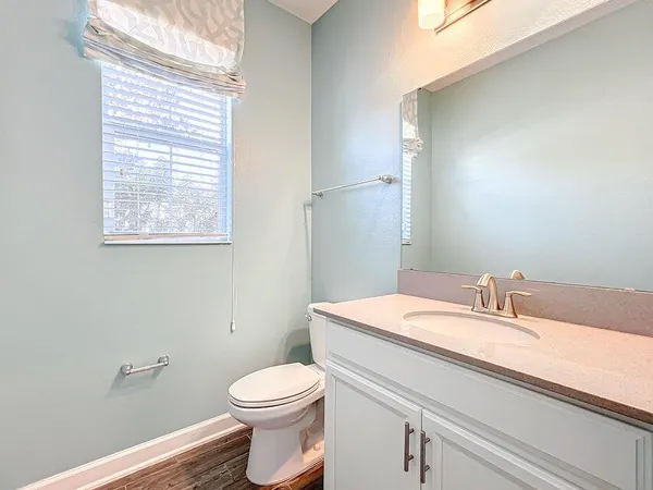 a view of an empty room with wooden floor and staircase