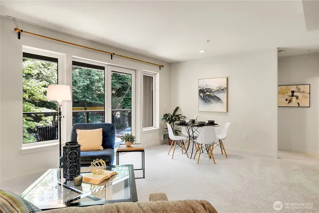 a living room with furniture a fireplace and a large window