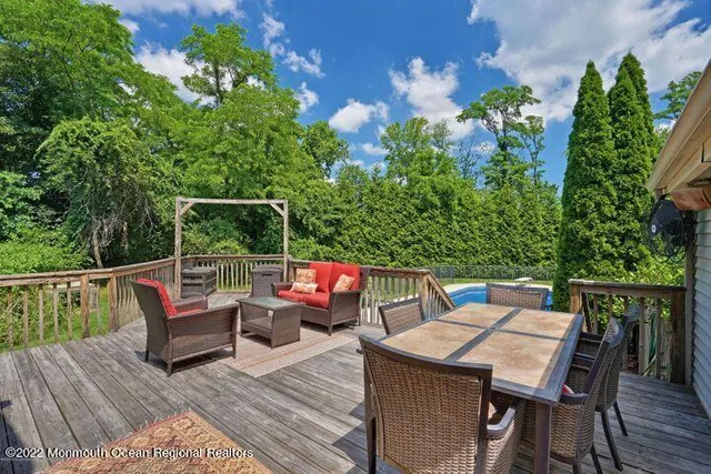 a balcony with wooden floor table and chairs